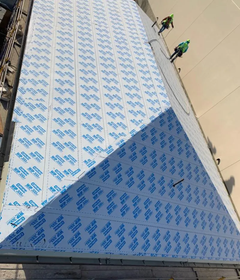 Professional roofers installing underlayment on a metal roof in Hudson